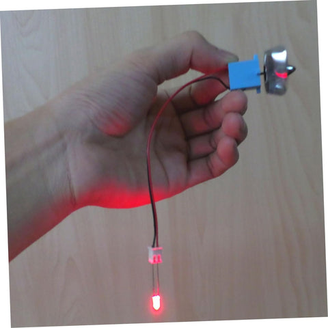 Hand holding Portable Mini Wind And Hydro Generator Dual Powered Educational Kit with LED lit, showing plastic turbine component.