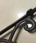 Hella Sturdy Rock Solid Cast Iron Wall Mounted Corner Support Brackets With A Killer Vintage Floral Design, angled view showcasing detailed metalwork.