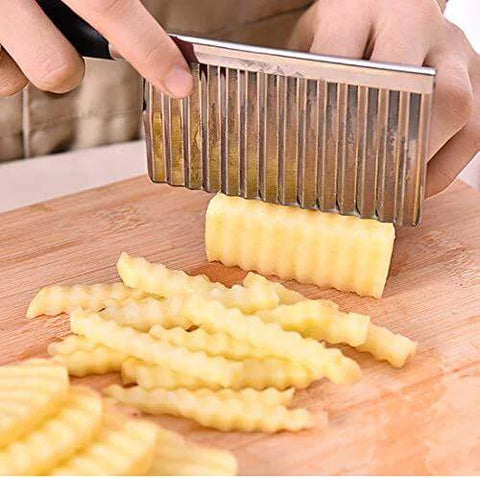 Crinkle cutter with stainless steel wavy blade; side view slicing potatoes into fries