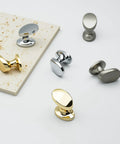 4 Pack Polished Brass Cabinet Knobs Set Solid Zinc Alloy Pulls on display with silver knobs for kitchen and bathroom furniture.