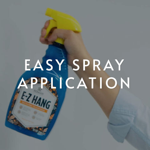EZ Hang Peel And Stick Wallpaper Helper Clear Spray 32 oz bottle held in hand for easy spray application