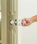 Person opening door with chrome doorknob, showcasing potential use for 20 Pack Ultra Thin Magnetic Cabinet Door Catches With Double Sided Tape And Screws.