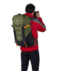 Person outdoors with PhotoSport X 35L AW Camera Backpack For DSLR And Mirrorless Gear With Rear Access And Mountain Ready Features