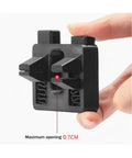 Hand holding portable wire welding fixture tool with adjustable soldering clamps and alignment guides for precise wire positioning.