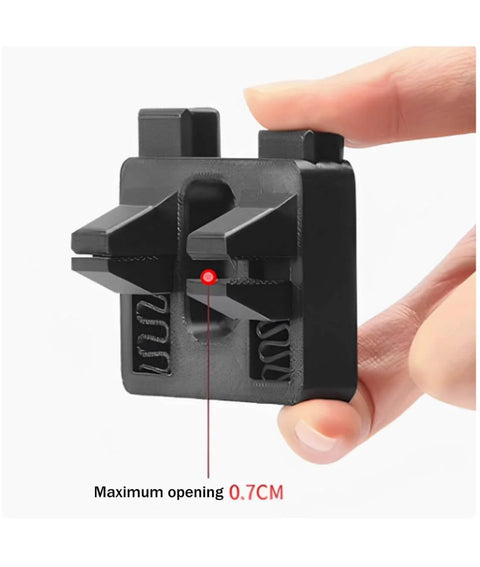Hand holding portable wire welding fixture tool with adjustable soldering clamps and alignment guides for precise wire positioning.