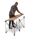 Man setting up Centipede Folding Table Top For Portable Work Stand Saw Horses, 24 Inch By 48 Inch Wood Top With 6 Quick Twist Locks