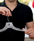 Person holding Heavy Duty Plastic Clothes Hangers Set Of 12 For Wardrobe Organization Space Saving Crystal Clear Hangers.