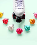 Two Pack Cat Paw Toe Stops For Quad Roller Skates 82A in mixed colors around a white skate, adjustable height rubber brake blocks