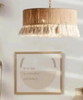 YAXDQUW Nordic Style Hemp Rope Pendant Light Hand‑Woven Cotton Tassel Shade hanging above framed artwork in a stylish interior.