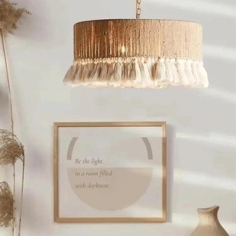 YAXDQUW Nordic Style Hemp Rope Pendant Light Hand‑Woven Cotton Tassel Shade hanging above framed artwork in a stylish interior.