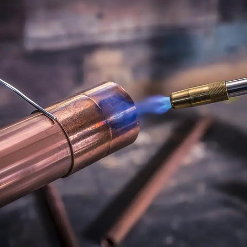 Trigger Start Butane Torch For Soldering And Welding in action, showing adjustable flame on copper pipe for precise metalwork.