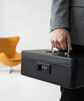 Keep Your Gear Locked Tight With This Keyless Mechanical Combination Lock For Cabinets And Drawers Featuring A Smooth Turntable Code Dial And Straight Hook For Hassle Free Secure Storage, black lockbox held by a person in a suit.