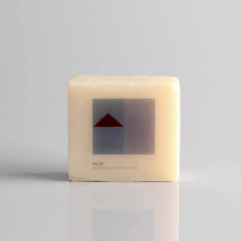 Close-up of a product box labeled 'Inkjet Waterslide Decal Paper' with minimalistic design in grey and red on a neutral background.