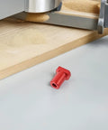 Red aluminum bench dog on workbench, part of Six Pack Aluminum Bench Dogs For Woodworking With Low Profile, Scratch Resistant Table Stops