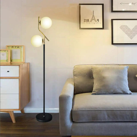 Two Milky White Glass Orbs Brass Finish Floor Lamp With Black Base, Modern Mid Century Style in a Living Room