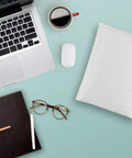 White Bubble Mailers 9.5 By 13.5 Inches Pack Of 25 Lightweight Padded Envelopes Self Seal on a desk with laptop and coffee