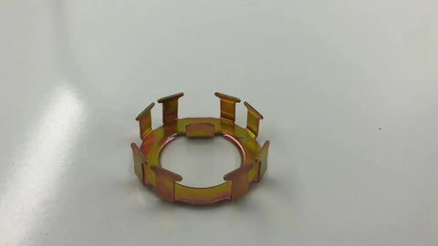 Top-down view of bronze-colored metal spindle nut retainer ring with eight rectangular tabs for EZ-Lube Dexter axle.