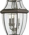 Close-up of Lancaster Traditional Three Light Outdoor Post Fixture In Antique Bronze Finish with glass shade and candelabra bulbs.