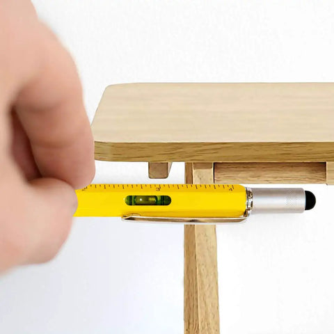 Close-up of 6 In 1 Multitool Pen Gift For Him And Dad with level and ruler in use on wooden table