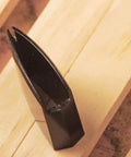 Sturdy Brass Habaki Collar Clip for Katana and Japanese swords locks Tsuba in place, shown upright on wooden surface.