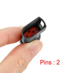 Rear brake pad wear sensor for Ford Transit; two-pin red connector, close-up held between fingers