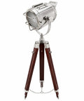 Chrome Spotlight Floor Lamp With Brown Wood Tripod Adjustable Height Studio Searchlight Lit Vintage Rustic Decor For Living Room Or Office Nautical Inspired Showpiece And Gift Idea with a chrome finish and wooden legs.