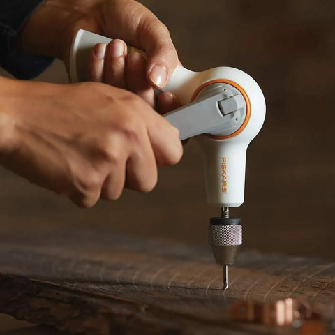 Hand Crank DIY Precision Hand Drill With Soft Grip Foldable Handle in use on wood, showcasing drilling feature and grip.