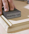 Hand using Four Grit Sanding Sponge Set 60 80 120 220 Grits, 4 x 2.8 x 1 Inch Assorted Blocks on a wooden edge