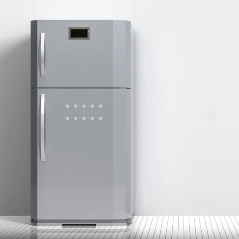 Silver double-door refrigerator with a digital display on top, standing on a tiled floor in a minimalistic kitchen setting.