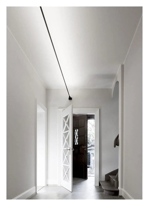 Effortlessly Sleek Modern Linear LED Wall Sconces With Remote Control For Cozy Bedroom And Living Room Vibes A Total Game Changer For Your Glow Up In Black Finish Dimmable Lighting illuminating a white hallway.