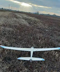 Model airplane flying over a grassy field during sunset, suitable for 12 Pack 9G Micro Servo Motors 360 Degree Geared for RC projects.