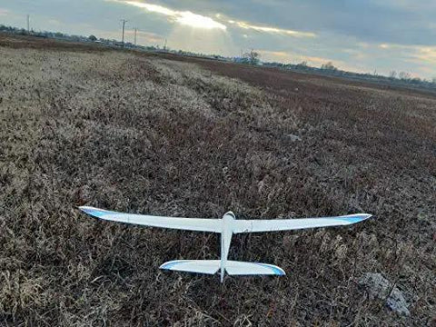 Model airplane flying over a grassy field during sunset, suitable for 12 Pack 9G Micro Servo Motors 360 Degree Geared for RC projects.