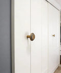 Retro Brass Cabinet Hardware Set with Greek Key Knobs on white closet door, showing hammered texture, zinc alloy drawer pulls