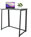 Rock Solid Collapsible Gaming Desk, No Sweat Folding Laptop Table For Home Office Hustle with laptop and plant, black frame and top.