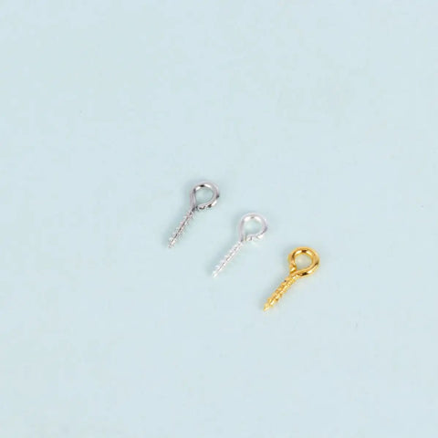 Three assorted sheep eye screws in silver and gold from the 600-Piece Sheep Eye Screw Kit With Plated Iron Round Eye Hooks And Self-Tapping Screws.