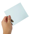 Hand holding a clear polycarbonate lens from the Premium Polycarbonate Welding Helmet Replacement Cover Lens Kit.