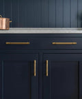 Six Pack Stripes Cabinet Pulls Antique Brass For Kitchen Cabinets And Dressers installed on dark blue cabinetry