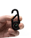 Hand holding Portable Double Sided Hiking Compass With Carabiner Pocket Sized Mini Outdoor Navigation Tool for hiking and camping