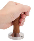 Hand holding 58mm Stainless Steel Coffee Tamper With Wooden Handle Heavy Duty Powder Pressing Tool For Richer Espresso Brew