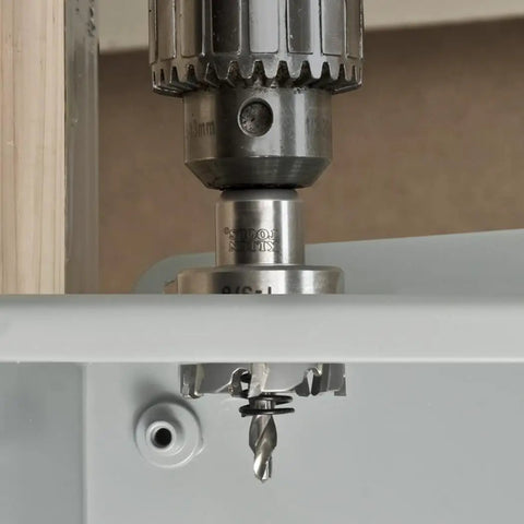 Drill with Heavy Duty Pro Grade Seven Eighths Inch Carbide Hole Cutter for stainless steel in action on metal surface