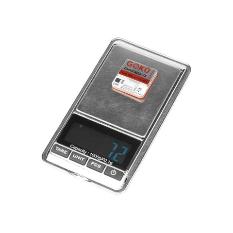 Goku GM10 Pro V3 GPS Module with Compass on digital scale, shows size, part of 72 channels, 30+ satellites, M10050 GNSS chip set