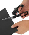 Professional laser-guided sewing scissors with ergonomic black handles cutting black cardstock for fabric crafts