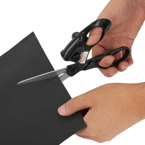 Professional laser-guided sewing scissors with ergonomic black handles cutting black cardstock for fabric crafts