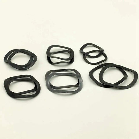 3-25mm Wave Spring Washers Kit With 65Mn Manganese Steel Gaskets, Elastic Washers, And Tri Washer Bearing Wave Pads In A Clear Storage Case. Flat black washers arranged on white background.