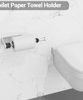 Wall-mounted toilet paper holder beside toilet in a bathroom setting with a marble wall background.