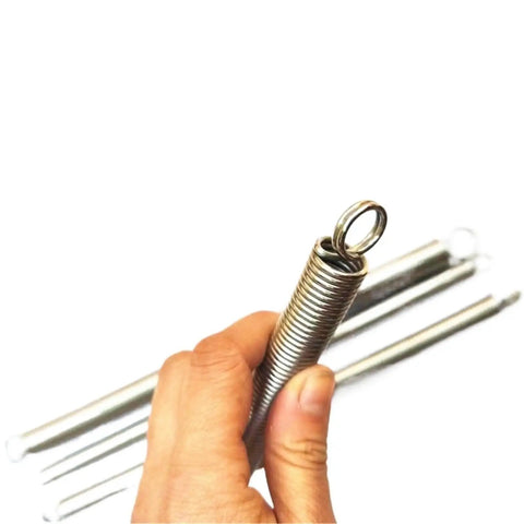 Hand holding a Beatdown Ready 304 Stainless Steel Pull Spring With Double Loop Hooks And Knockout Tension For Tough Diy Jobs And Garage Shop Tweaks At 25 Mm Outer Diameter.