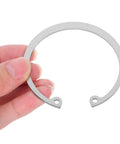Hand holding part of the 5 Piece Stainless Steel C Clip Retaining Ring Set For Pins Shafts And Studs Durable Internal Snap Ring Kit.