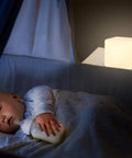 4 Inch Dimmable LED Night Light Mood Cube With 16 RGB Colors, white cube glowing next to a sleeping baby in a crib.