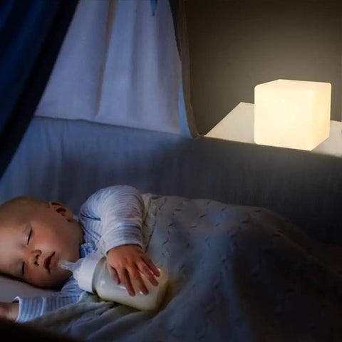 4 Inch Dimmable LED Night Light Mood Cube With 16 RGB Colors, white cube glowing next to a sleeping baby in a crib.