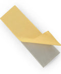 Peeling adhesive protective layer on rectangular panel, showcasing material texture.